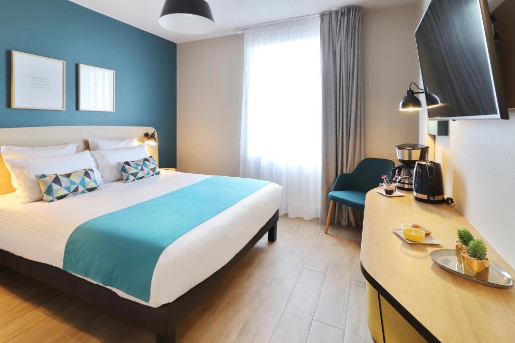 ラベージュにあるAppart'City Confort Toulouse Diagora Labègeのベッドとデスクが備わるホテルルームです。