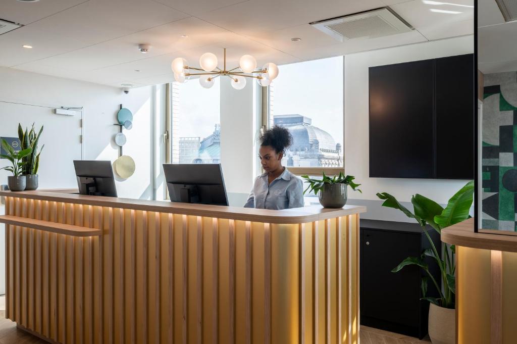 a man sitting at a counter in an office at B&B HOTEL Antwerpen Centrum in Antwerp