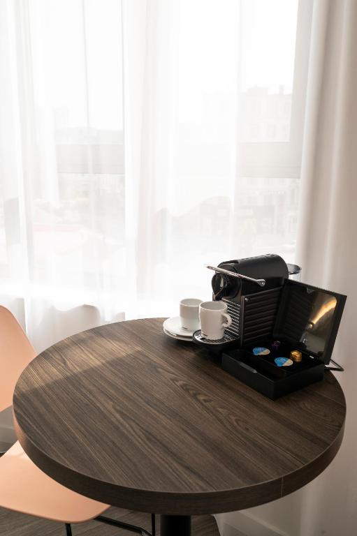 a wooden table with two cups and a printer on it at B&B HOTEL Antwerpen Centrum in Antwerp