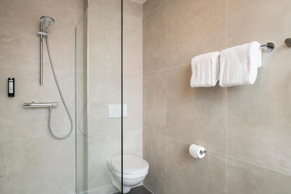 a bathroom with a toilet and a glass shower at B&B HOTEL Antwerpen Centrum in Antwerp