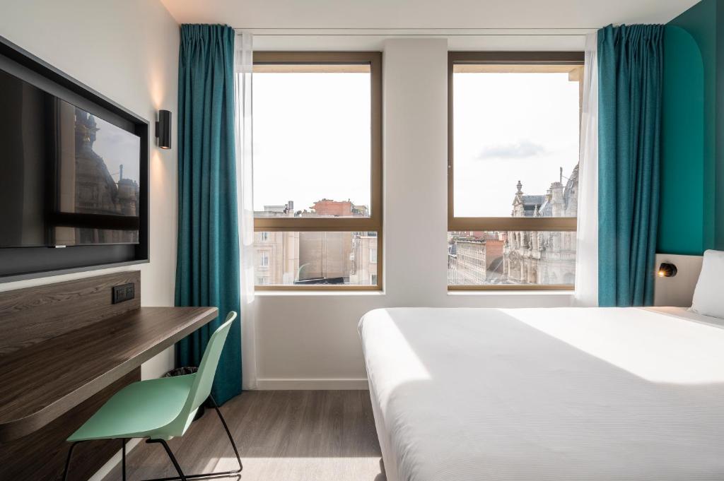 a hotel room with a bed and a flat screen tv at B&B HOTEL Antwerpen Centrum in Antwerp