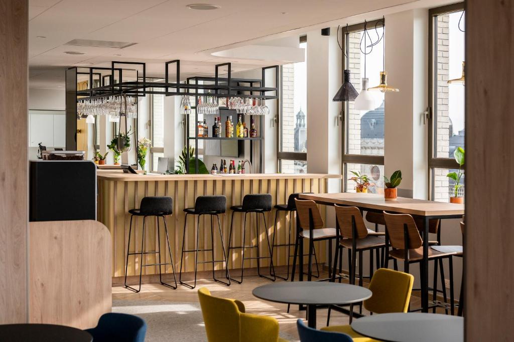 a restaurant with a bar with chairs and tables at B&B HOTEL Antwerpen Centrum in Antwerp