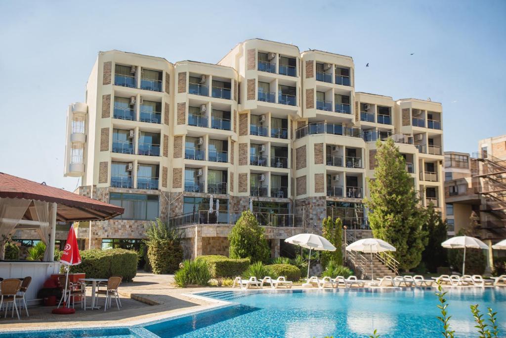 ein Hotel mit einem Schwimmbad vor einem Gebäude in der Unterkunft Amfibia Beach Complex in Sonnenstrand