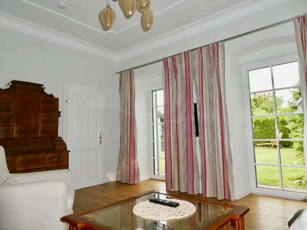 a living room with a table and two windows at Steyr City Apartment mit 2 Schlafzimmer in Steyr