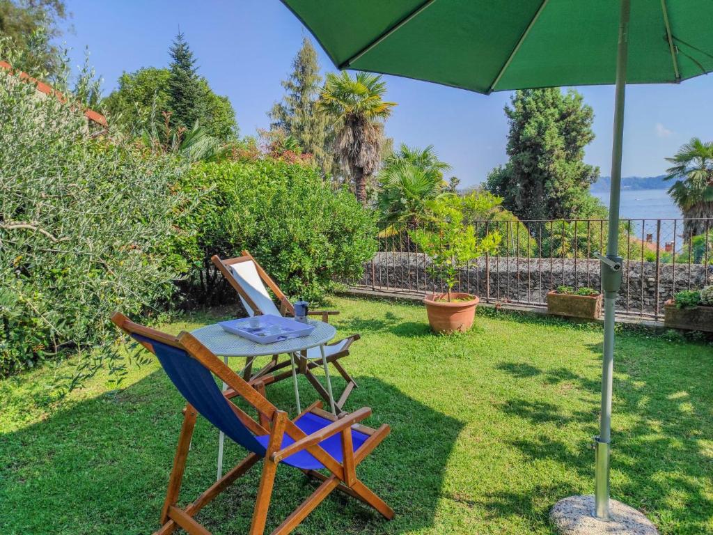 uma mesa e duas cadeiras debaixo de um guarda-sol em Apartment Lo Scoiattolo by Interhome em Belgirate