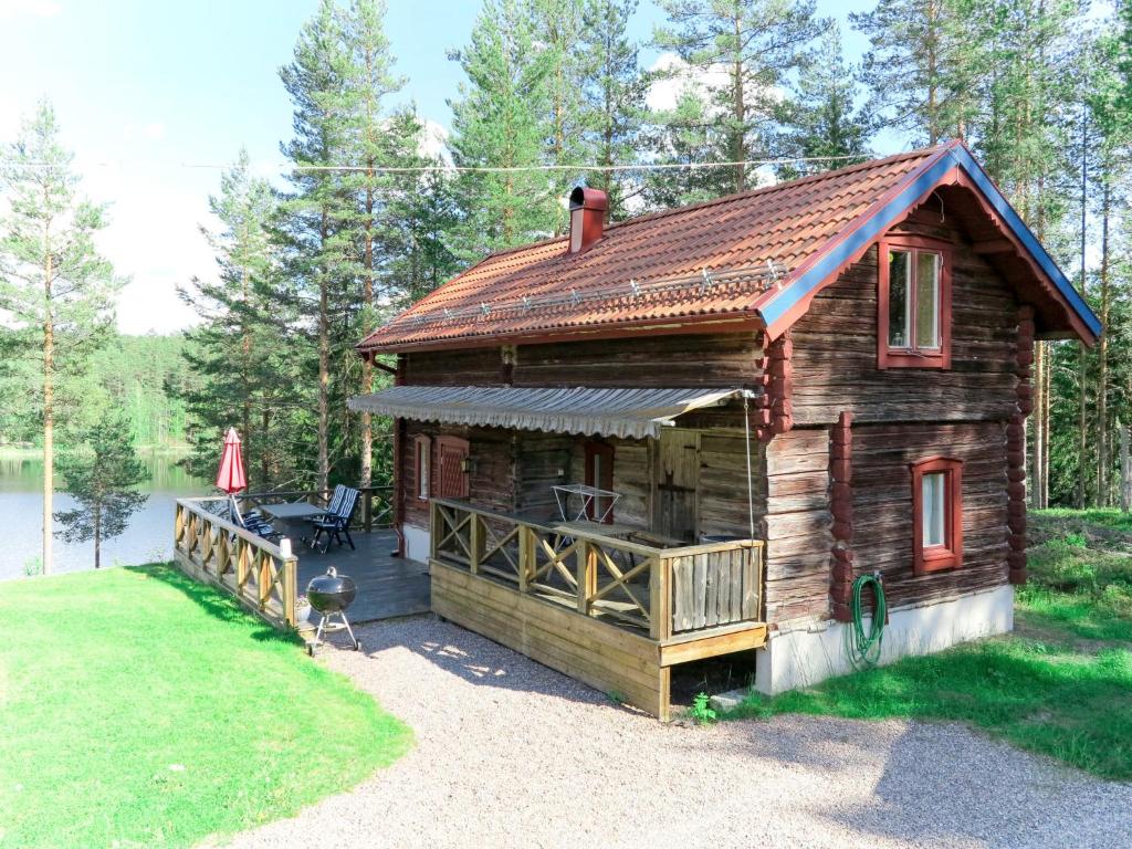 une cabane en rondins avec une terrasse à côté d'un lac dans l'établissement Chalet Nedre Gärdsjö by Interhome, à Rättvik