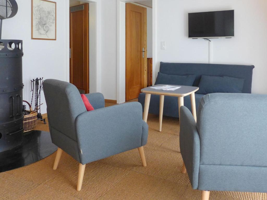 een woonkamer met twee stoelen en een tafel bij Apartment Chalet Holzwurm-1 by Interhome in Grindelwald
