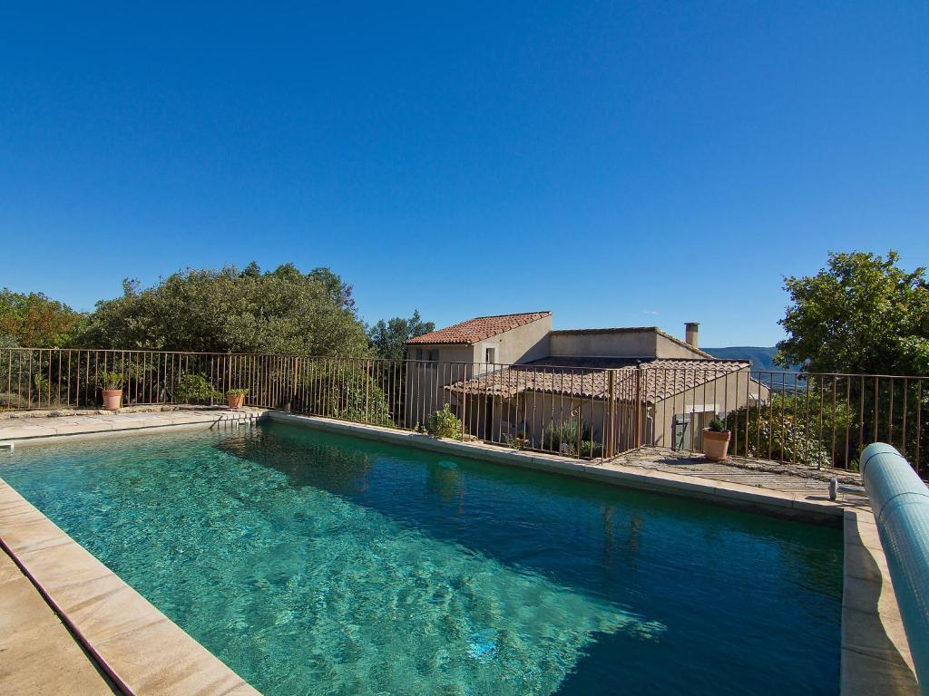 a large swimming pool in front of a fence at Holiday Home Les Cairnes by Interhome in Viens