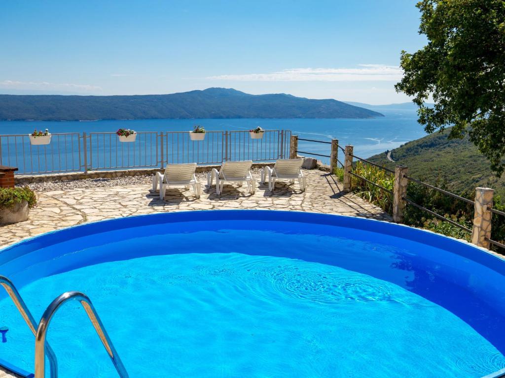 a large blue swimming pool with a view of the ocean at Holiday Home Kristijana by Interhome in Martina
