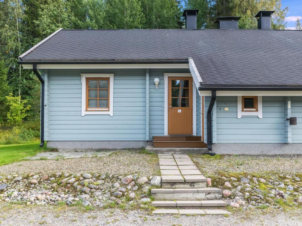 LahdenperäにあるHoliday Home Yläperho 2 by Interhomeの茶色の扉のある小さな青い家