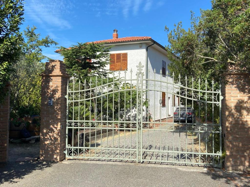 Biała brama z domem za nią w obiekcie Apartment Sonia by Interhome w mieście Riparbella