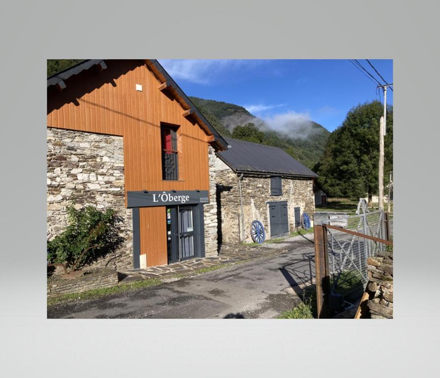 a building with a sign on the side of it at L'Ôberge in Arlos