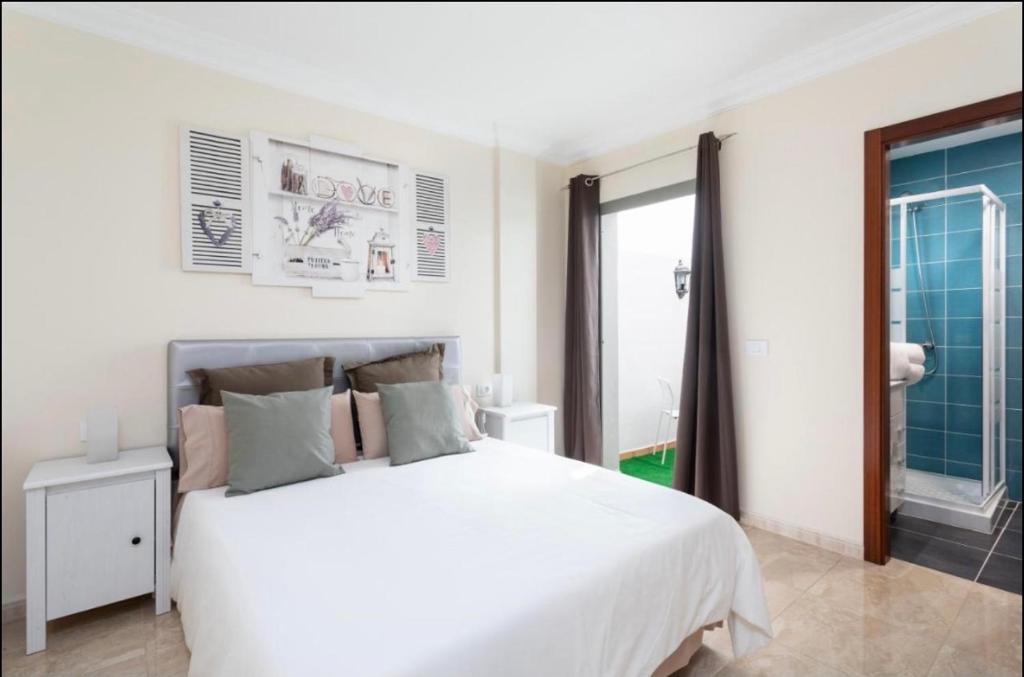 a white bedroom with a large bed and a window at Apartamento rolycar 103 in Icod de los Vinos
