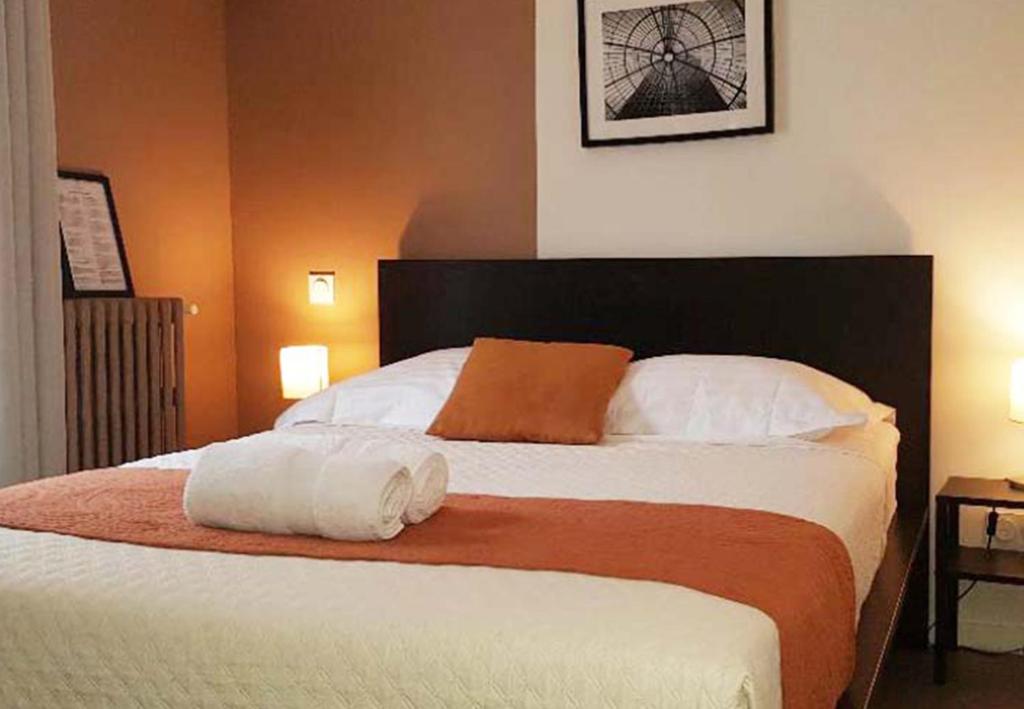 a bedroom with a large bed with two pillows at Résidence Ramblas in Toulouse