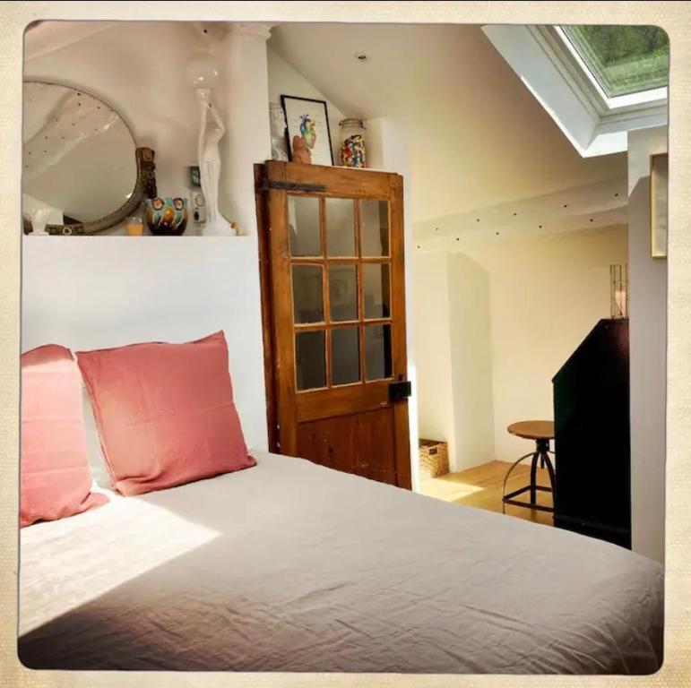um quarto com uma cama com almofadas cor-de-rosa e um espelho em Le Josephine em Siguer