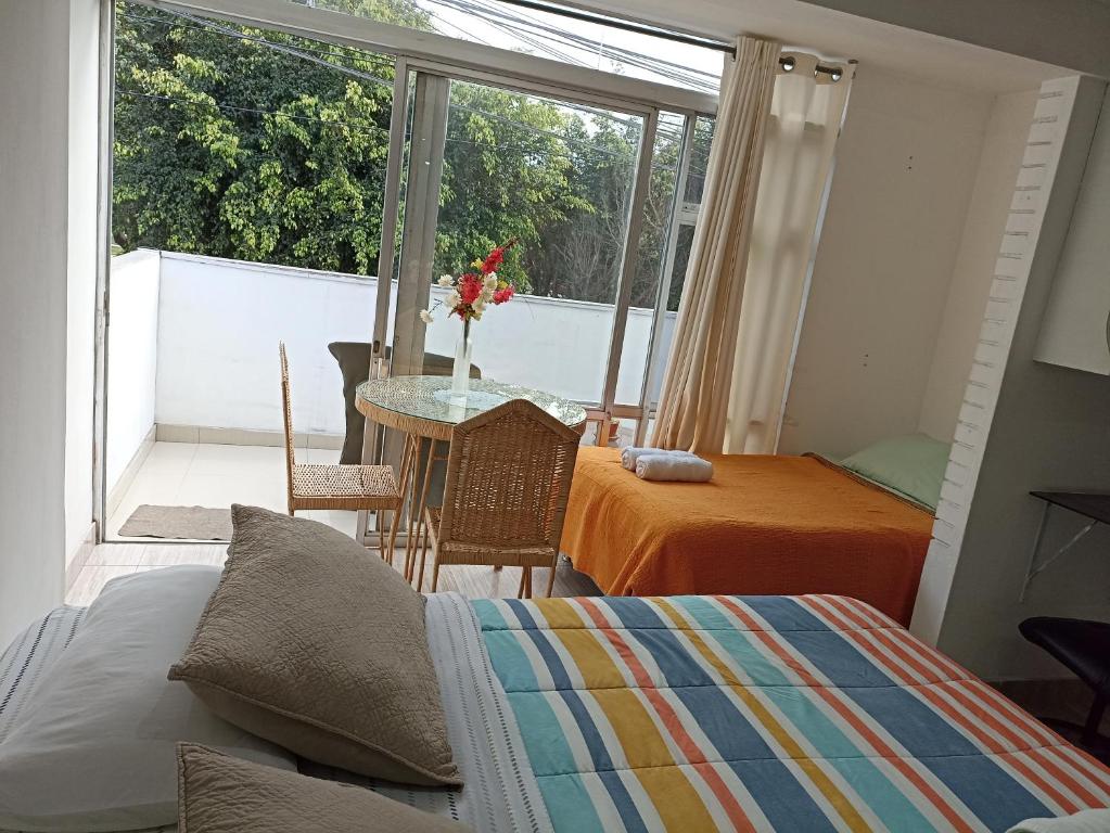 - une chambre avec un lit, une table et un balcon dans l'établissement Monterrico Suites Hotel, à Lima