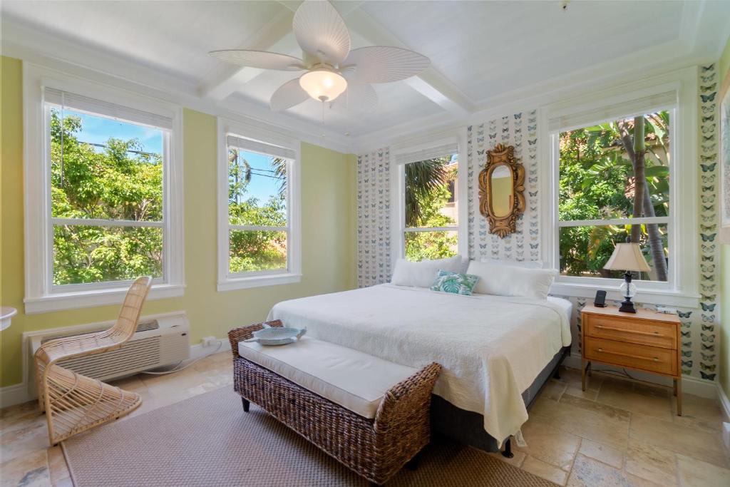 a bedroom with a bed and a chair and windows at Palm Beach Island Condominiums in Palm Beach