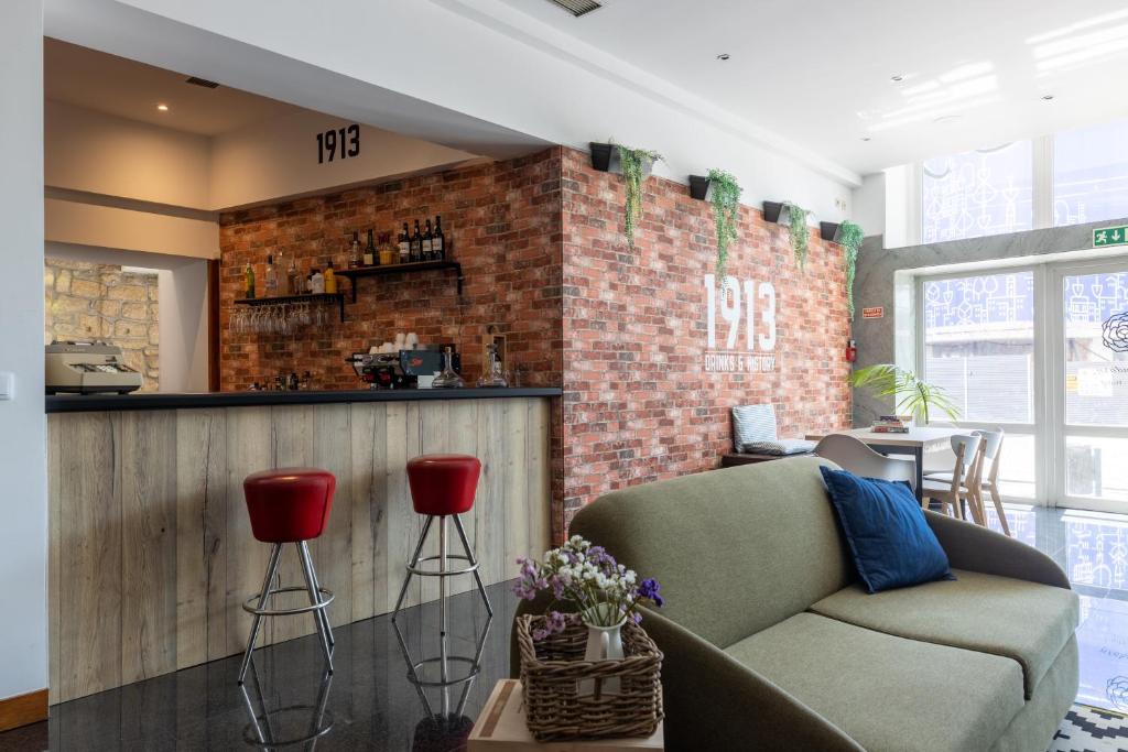 a living room with a couch and a brick wall at Legendary Porto Hotel in Porto