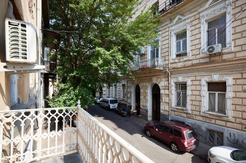 czerwony samochód zaparkowany na ulicy obok budynku w obiekcie Apartment Mate w mieście Tbilisi City