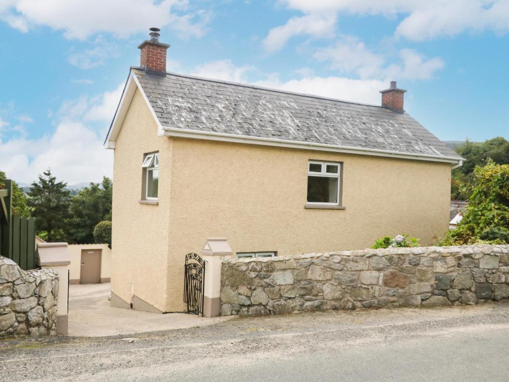 a house with a stone wall next to a street at Whitethorn House in Newry