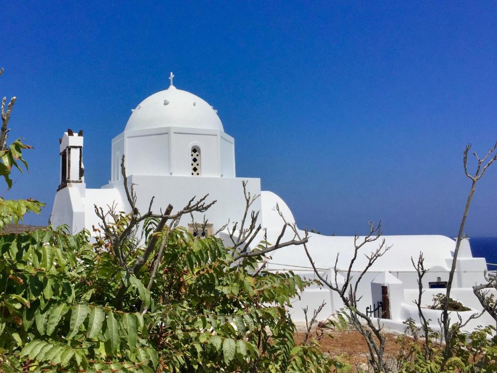 a white building with a cross on top of it at Ariana Eco Suites Adults Only in Fira