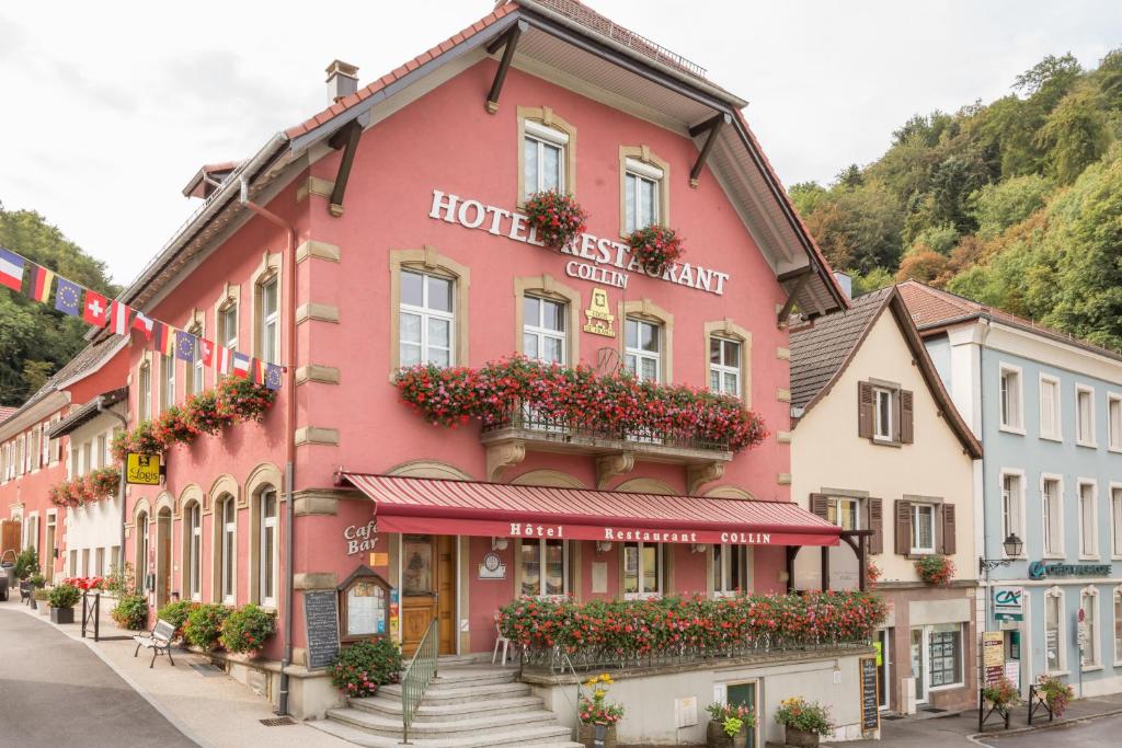 a pink building on a street with flowers at HOTEL RESTAURANT COLLIN in Ferrette