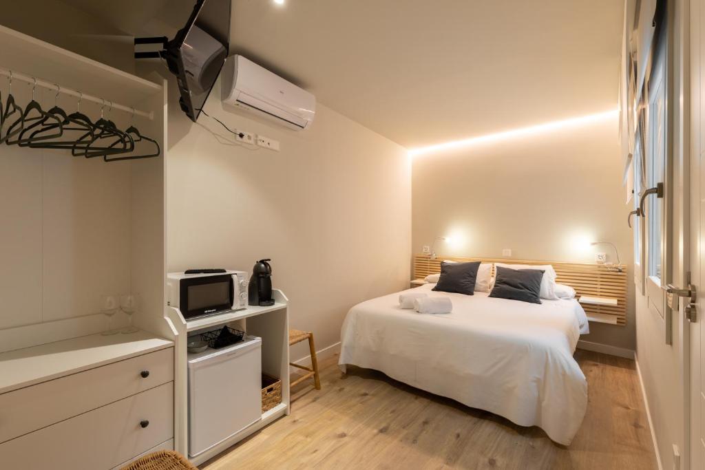 a white bedroom with a bed and a tv at Double Room in ToledoRooms VistaPark in Toledo