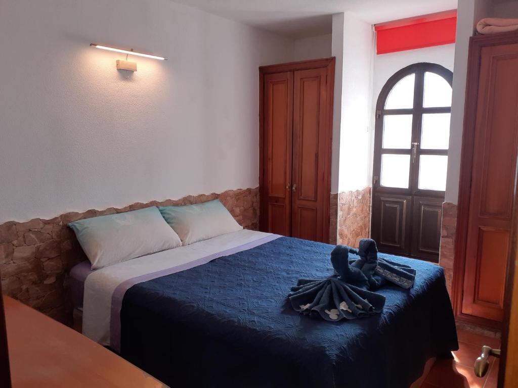 1 dormitorio con 1 cama con manta azul y ventana en Beautiful coastline bungalow near the ocean 50 m, en Costa de Antigua
