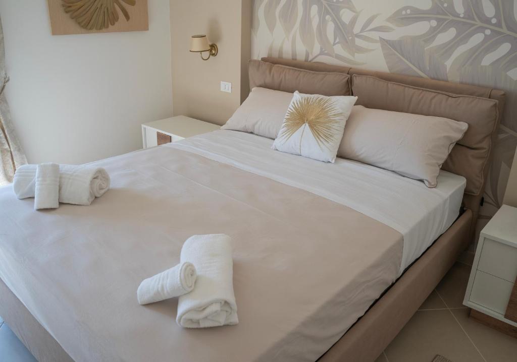 Oasi Smart Rooms في كالتانيسيتا: غرفة نوم بسرير ابيض كبير عليها مناشف