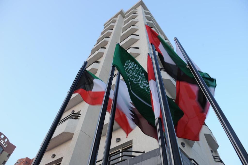 un groupe de pavillons volant devant un bâtiment dans l'établissement Salmiya Casa Hotel, à Koweït