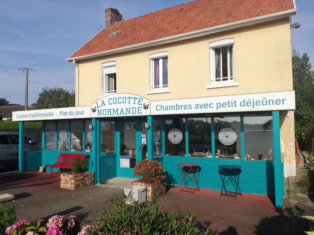 una tienda frente a un edificio azul y blanco en La cocotte normande, en Coudeville