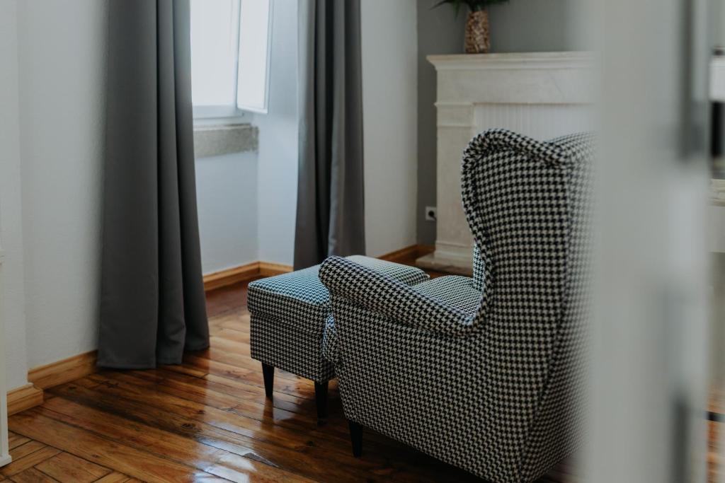 uma cadeira numa sala de estar com lareira em Elvas the Queen Residence em Elvas