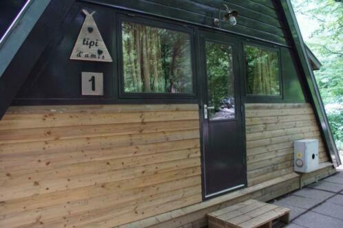 a front porch of a log cabin with a sign on it at Tipi d'Amis in Durbuy