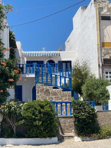 um edifício azul com uma escada em frente em Marena 1 em Makry Gialos