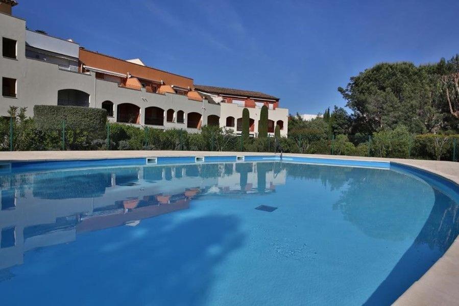 une grande piscine devant un immeuble dans l'établissement Appartement 3 chambres climatisé dans Résidence calme avec Piscine et Tennis, à Cavalaire-sur-Mer