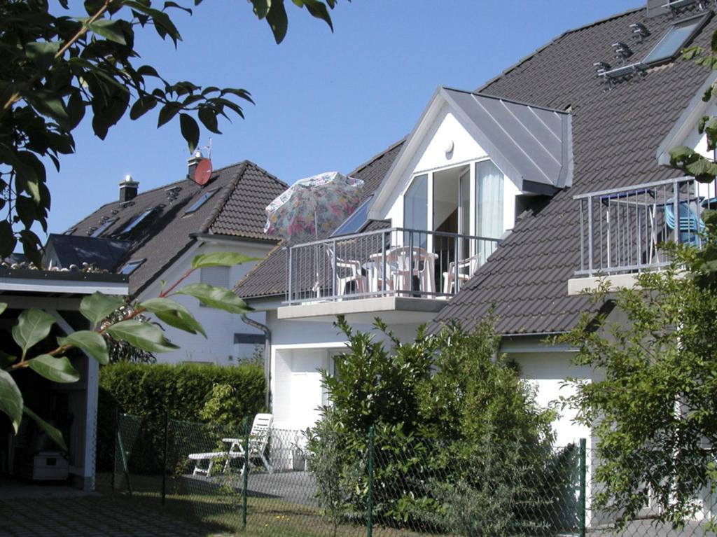 ツィングストにあるStrandperle 11, PP außenのバルコニーと屋根付きの白い家