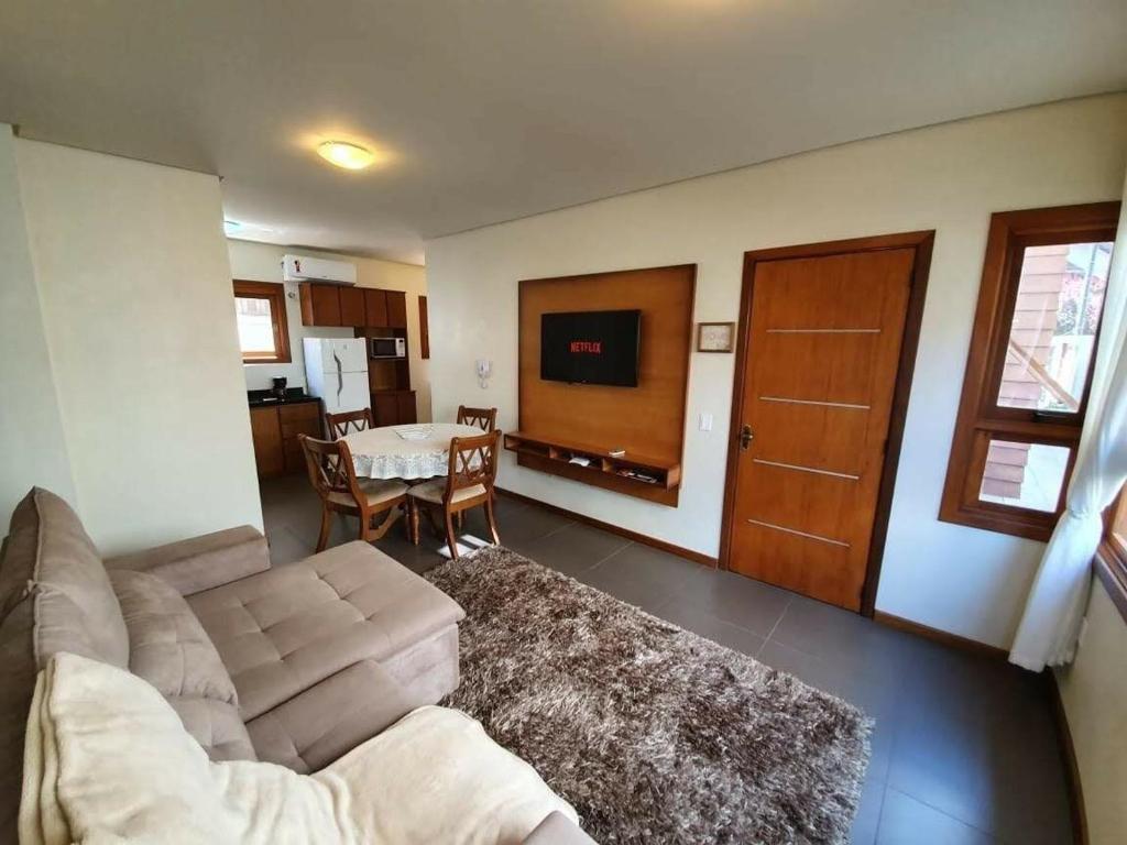 a living room with a couch and a table at Apto Rua Coberta Gramado in Gramado