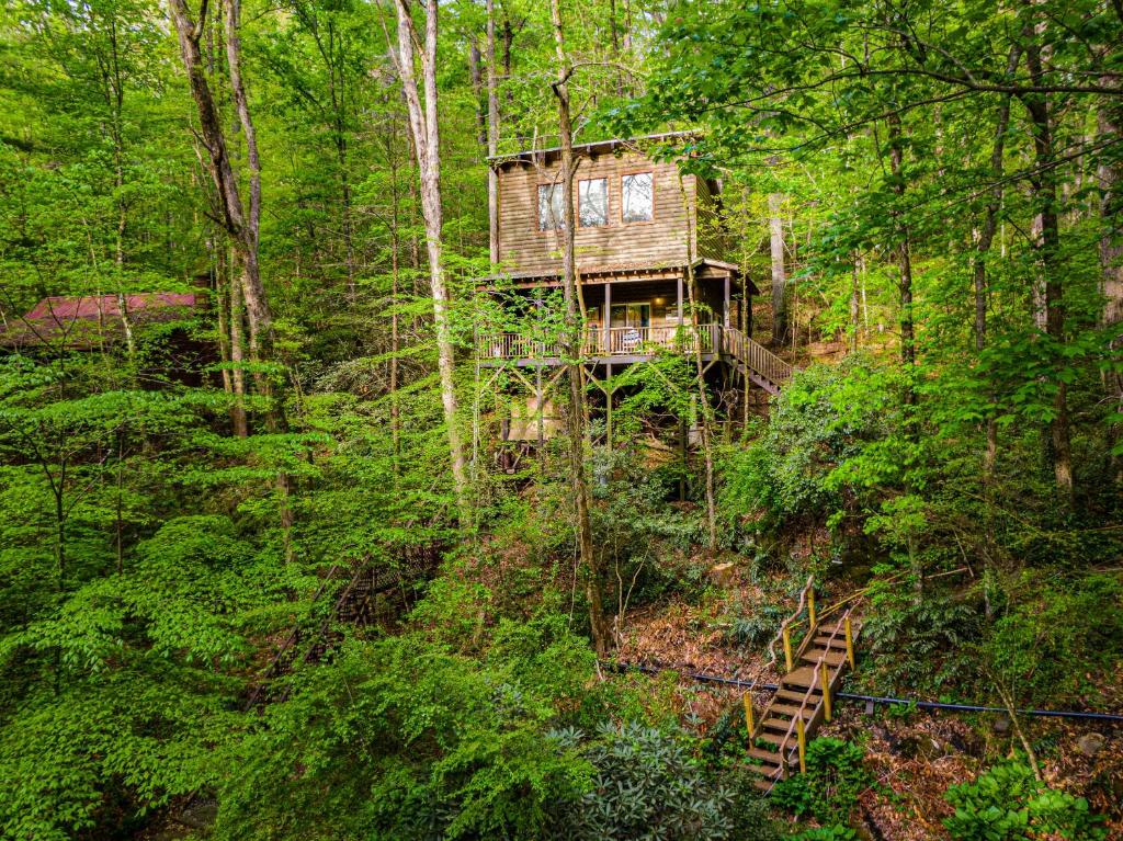 a tree house in the middle of the forest at The TreeHouse - Rocking Chair Deck with Hot Tub below, Walking Distance to Downtown Helen, Sleeps 5 in Helen