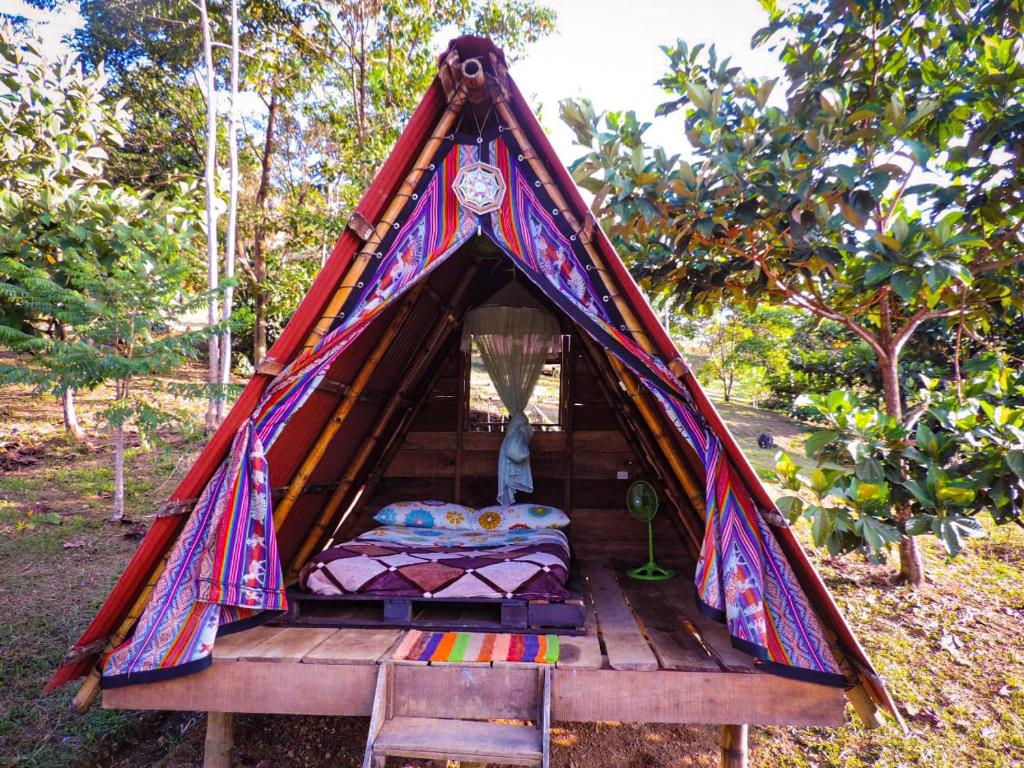 ein farbenfrohes Zelt mit einem Bett darin in der Unterkunft Kindiwayra Ecohostal in Pepino