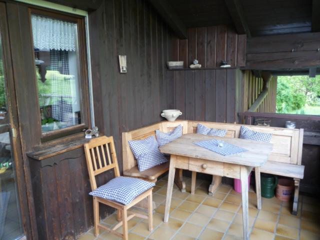einen Holztisch und Stühle auf einer Terrasse in der Unterkunft Mondscheinwinkl in Flintsbach