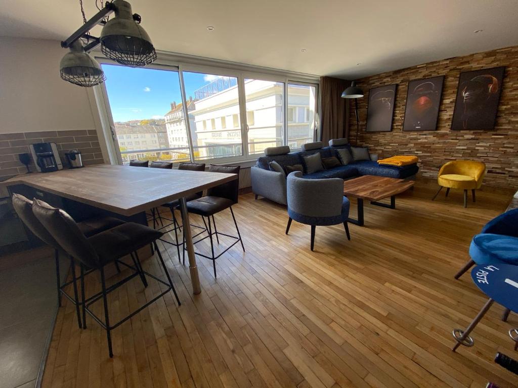 a living room with a large table and chairs at Bliss’appart boulogne/mer logement avec balnéothérapie in Boulogne-sur-Mer
