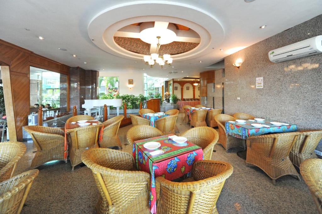 a restaurant with wicker chairs and tables in a room at Kenting Holiday Hotel in Hengchun South Gate