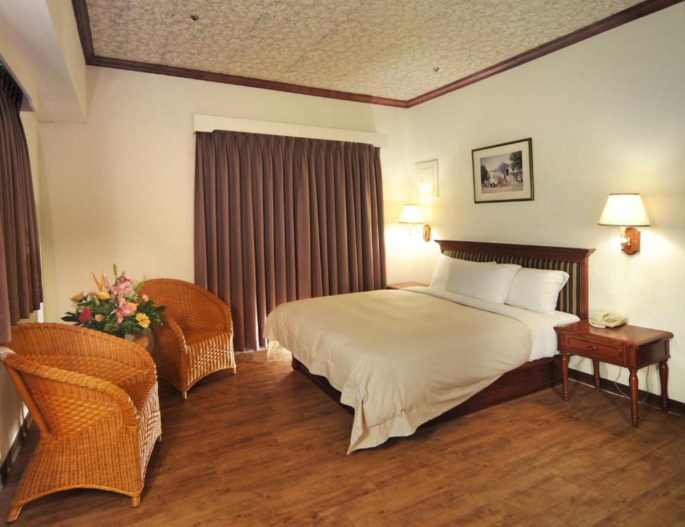 a hotel room with a bed and a chair at Kenting Holiday Hotel in Hengchun South Gate