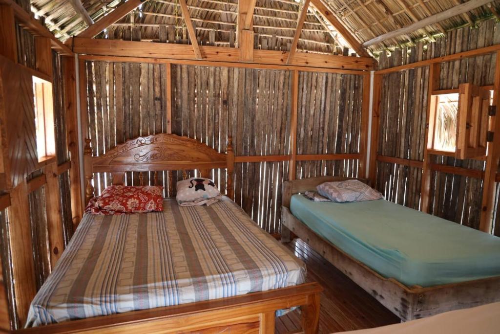a bedroom with two beds in a bamboo house at Cabañas Tubasenika in Ailigandí