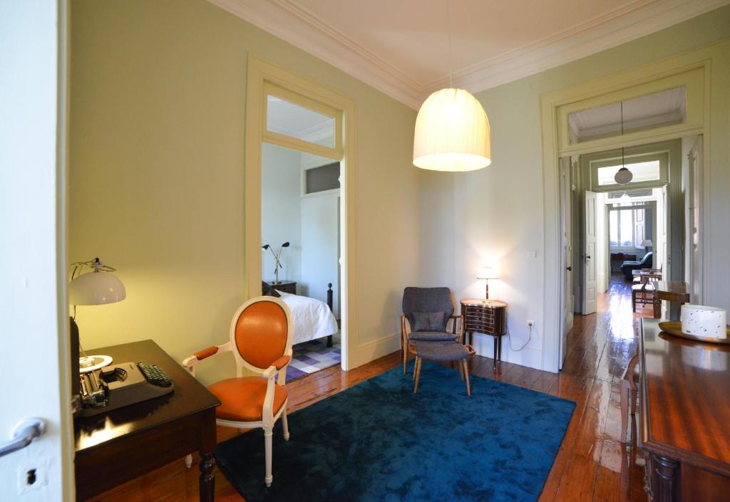 a living room with a bed and a desk and chair at Maison des Amis Porto in Porto