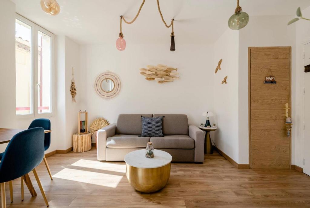 a living room with a couch and a coffee table at Appartement le Quai du Port Cassis parking clim in Cassis