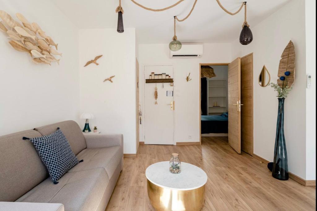 a living room with a couch and a table at Appartement le Quai du Port Cassis parking clim in Cassis