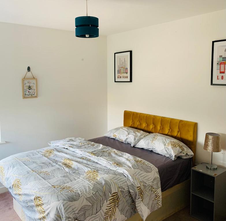 The Hive, Private Large Double Room, Barking, Close to London في باركينغ: غرفة نوم بسرير مع اللوح الأمامي الأصفر