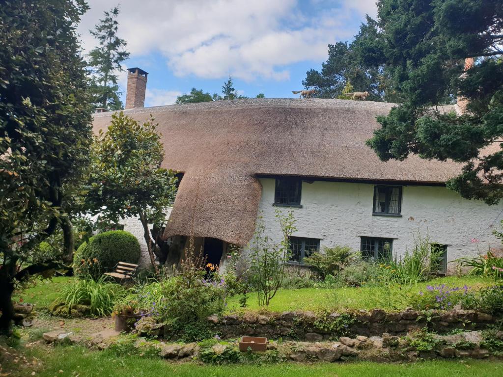 a thatch roofed house with a thatched roof at Ford House in Stockland