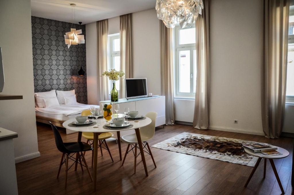 salon ze stołem, krzesłami i kanapą w obiekcie Baross Boutique Apartman w Győr
